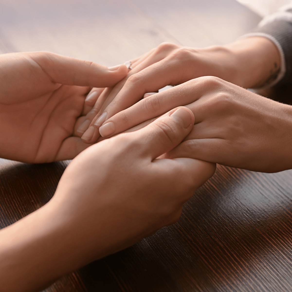 Two people holding hands in support